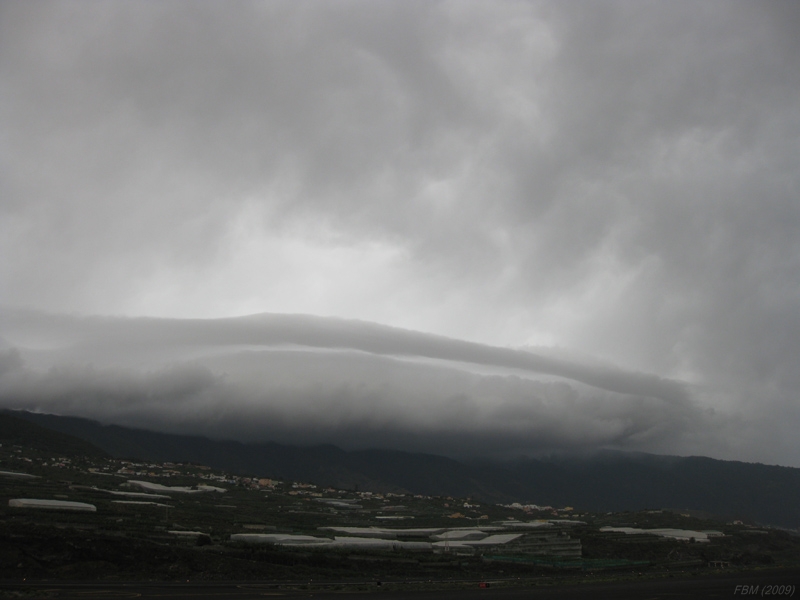 Altostratus opacus y Stratocumulus
"Nube capuchón que parece un arcus"

Nube orográfica sobre las cumbres de La Palma bajo una gruesa capa de nubes medias.
Ver vídeo:
[b]http://www.youtube.com/watch?v=vzd0VBx_LPY[/b]
