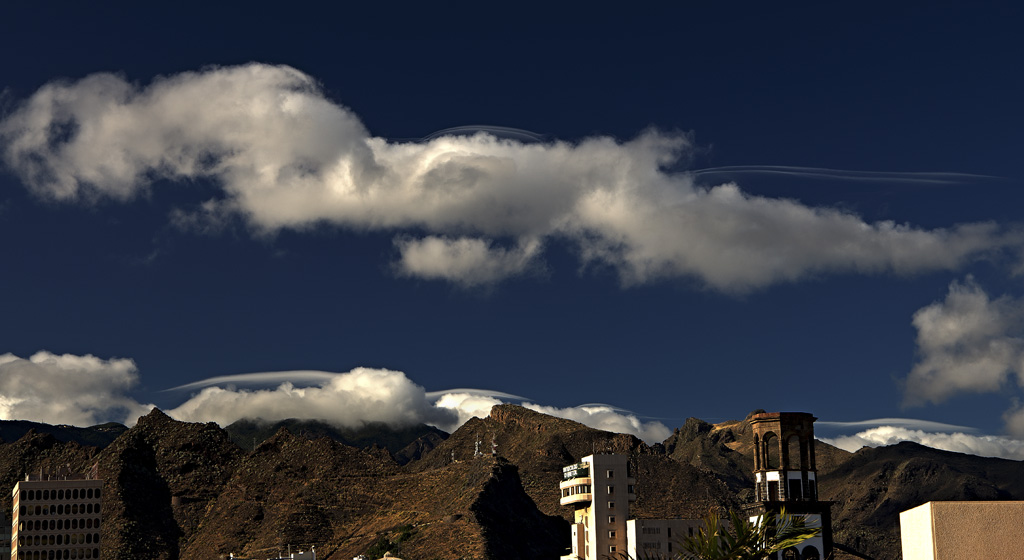 Stratocumulus pileus
A principios de julio se pudieron observar en Santa Cruz de Tenerife estas curiosas "lisuras", nombre que se da localmente a las nubes de gran longitud horizontal con respecto a su altura y que ocasionalmente tienen aspecto lenticular. Técnicamente son unas nubes accesorias conocidas como pileus que se suelen formar asociadas a Cumulus y Cumulonimbus a causa de las corrientes de aire ascendentes que acompañan a estas nubes. Es más raro observarlas sobre Stratocumulus, como en el caso de la foto.
