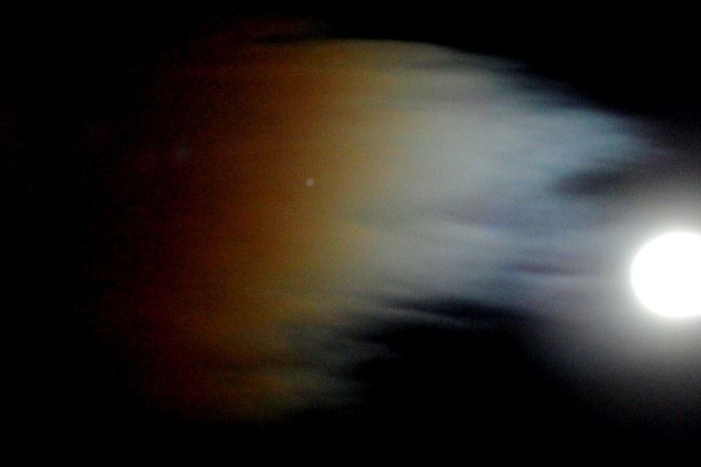 Iridiscencias a la luz de la luna nueva
Durante la fase de luna llena una solitaria nube la merodea y el efecto es esta iridiscencia. 
