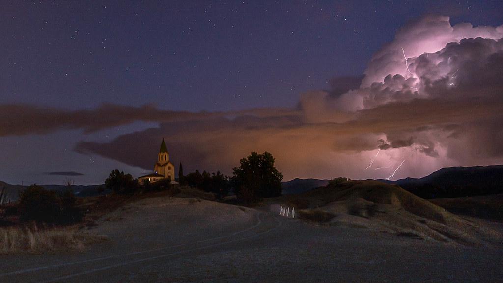 Noche celestial
Cumulonimbos "incus" nocturno con rayos iluminando el cielo del santuario de Puig-Agut. Escena de una dulce película de una noche celestial
