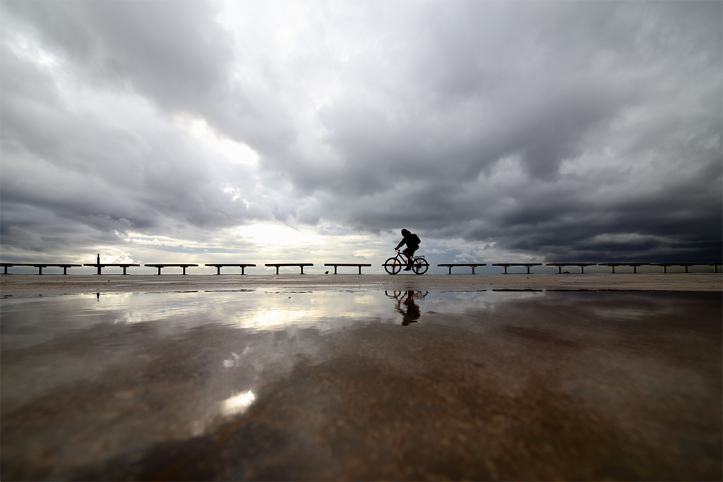 Bicicletas entre nubes
Después de una noche lluviosa el suelo encharcado del paseo marítimo de Barcelona refleja el cielo nublado, creando así una simetría de tonos grises y marrones por la que circulan peatones y ciclistas.  
Álbumes del atlas: aaa_no_album