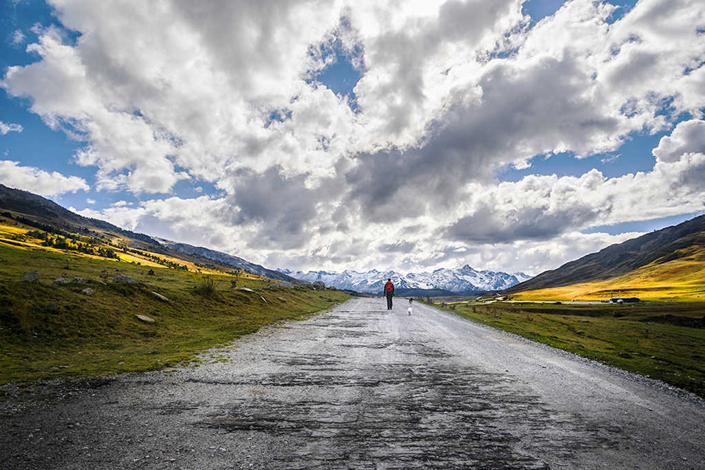 Inmensidad
Hombre caminando por carretera desierta baja un cielo cargado de amenazantes nubes
