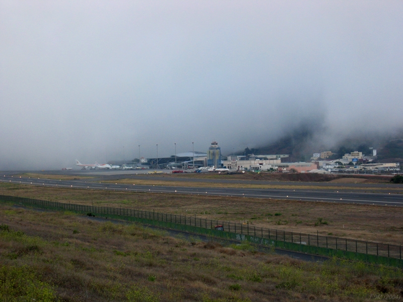 Niebla en el Aeropuerto de los Rodeos (Tenerife)
Imagen relativamente habitual con tiempos alisios, en la que podemos ver la mitad del aeropuerto (la parte de la pista orientada hacia el NW cubierta por la niebla, mientras que la parte de pista y la cabecera qiu eda haciea el Sureste queda libre de ella. 
