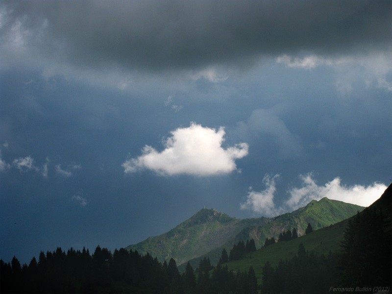 Contrastes
Un rayo de sol se cuela entre las nubes de tormenta e ilumina un pequeño cúmulo y la montaña generando un vistoso contraste. 
