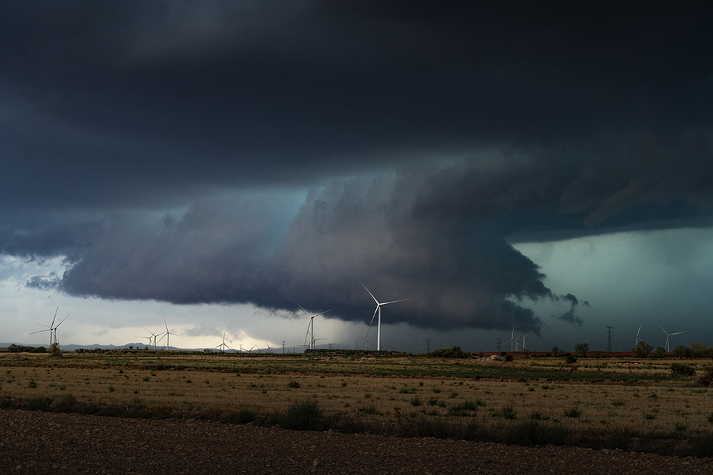 El pasado 29 de Agosto, tuve la suerte de poder venir desde Tenerife a la península a fotografiar tormentas, y entre ellas esta, una potente supercélula que afectó el Sur de la provincia de Zaragoza. Una fotografía que tomé desde un campo eólico, donde los molinos aportaban ese toque de grandeza a la escena gracias a su escala en la imagen. 
