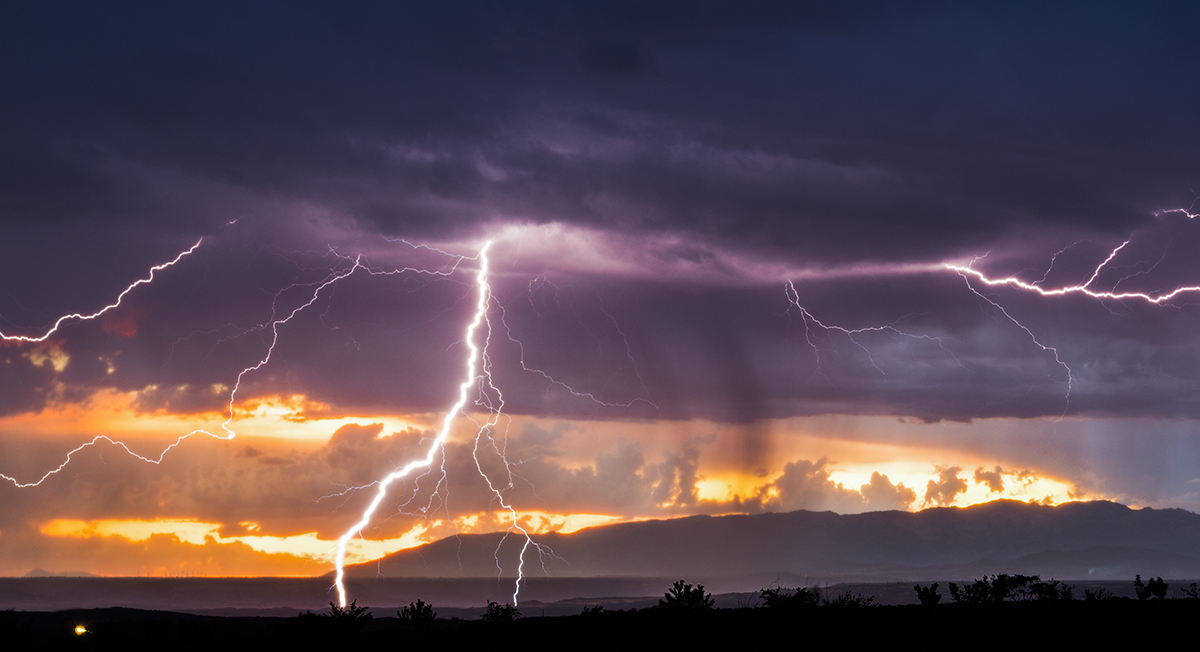 Precioso momento en el que una célula de tormenta solitaria suelta algunos rayos a tierra coincidiendo con el atardecer. 
