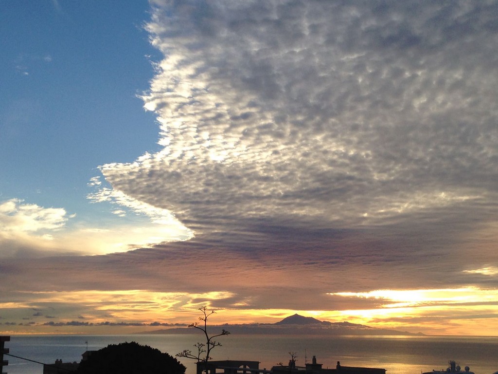 El palacio del rey
Entre dos capas de nubes asoma el padre Teide sobre la figura difuminada de la isla de Tenerife
