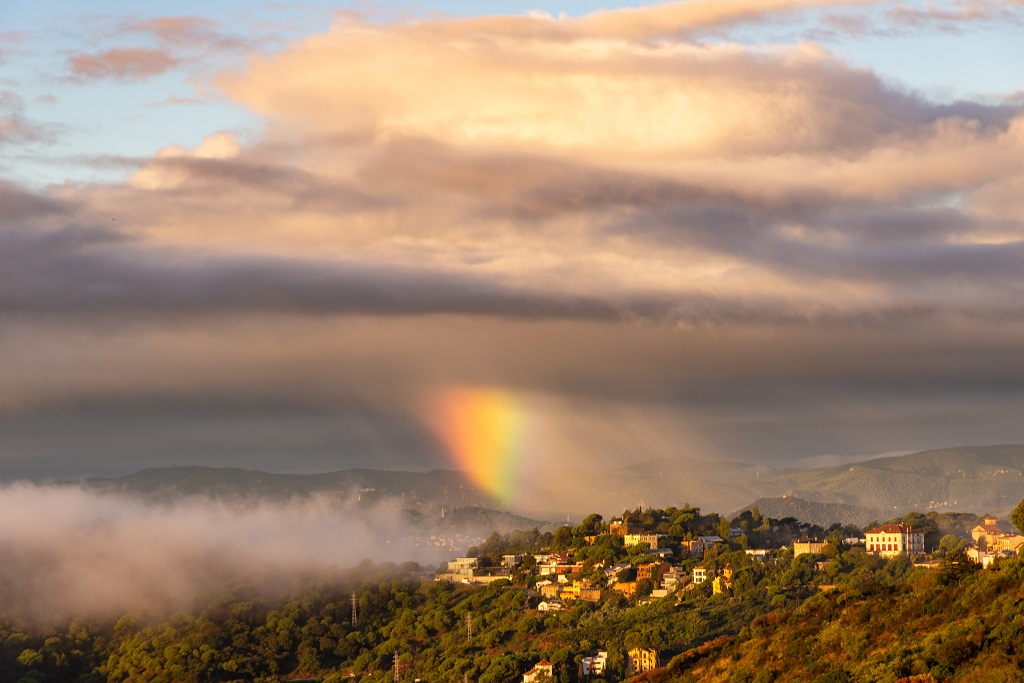 Una pequeña cortina de precipitación situada justo en el lugar adecuado para reproducir una porción de arcoíris que practicamente coincide con la extensión de la cortina. Parece que llueven colores.
