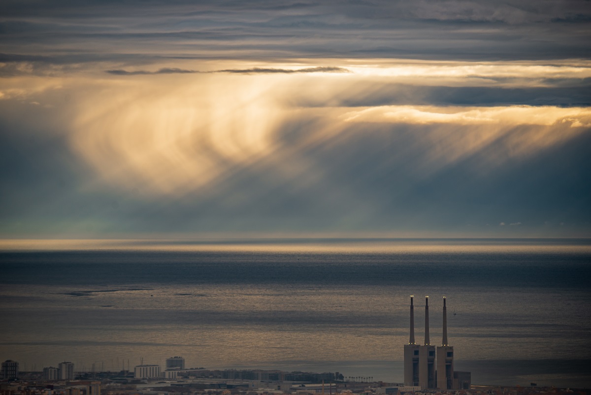 Unas virgas caen de nubes medias y las vemos resaltadas gracias a unos rayos crepusculares que se filtran por rendijas en la caba de nubes. 
