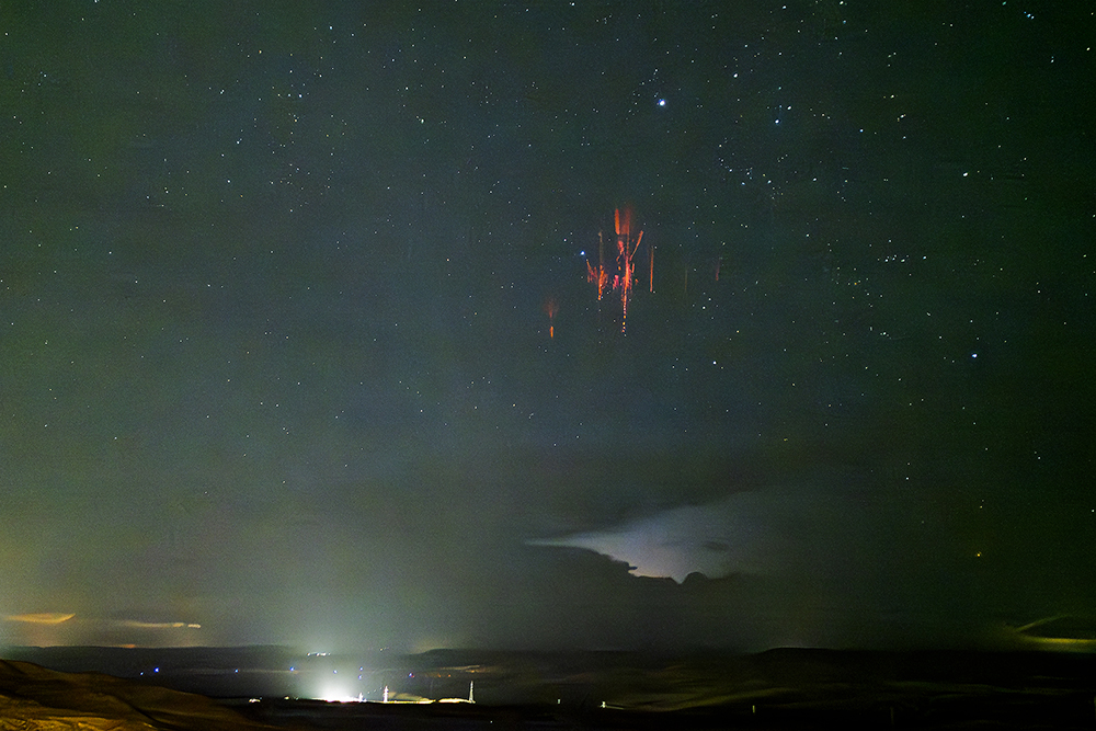 Esto que vemos es un sprite, un tipo de eventos o fenómenos luminosos transitorios de la alta atmósfera generados desde los topes de intensas tormentas hacia arriba. Suelen aparecer en agrupaciones rojas/azules y emanan de los topes tormentosos hacia niveles altos de la atmósfera. Se producen muy escasamente, lo que unido a su muy débil luminosidad, pero aún visible al ojo humano, y que apenas duran unas milésimas de segundos, es uno de los fenómenos meteorológicos, si no el que más, más difíciles de fotografiar. Tuve la suerte de verlo y fotografiarlo en la madrugada del 4 de septiembre de 2024 desde Belinchón, Cuenca,  hacia un sistema tormentoso que se encontraba al sur de la provincia de Zaragoza, a unos 170 kilómetros de distancia.  
