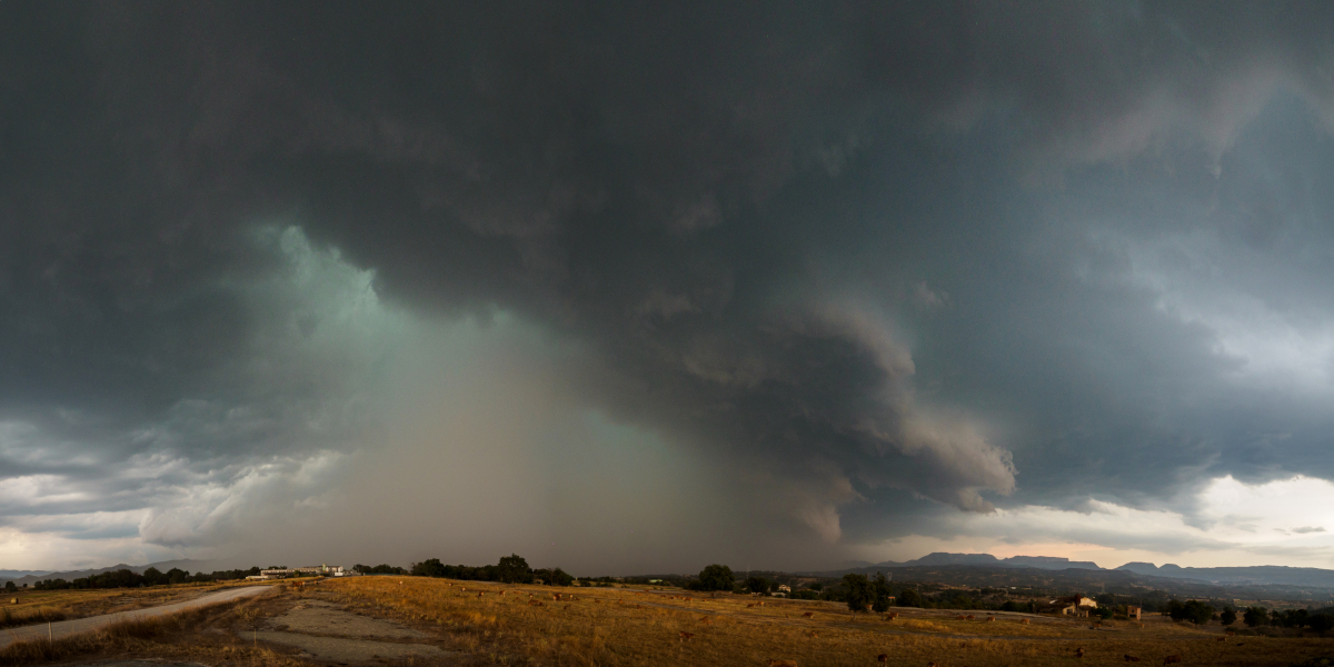 Aquella tarde de agosto esperava la tormenta que se acercaba por detrás de la Sierra de Bellmunt. Justo al pasar la montaña se reactivó en pocos minutos i se convirtió en   esta espécie de monstruo que dejó una impresionante granizada (con piedras grandes como huevos de gallina y más) en Sant Pere de Torelló, pueblo de unos 2500 habitantes. El Ayuntamiento informó que resultaron dañados cerca de 300 coches y un millar de edificios, entre viviendas e industrias.

Me alejé del lugar antes de que me pillara, y desde un poco más al sur pude observar los momentos álgidos de la tormenta sobre el pueblo hasta que unas fuertes ráfagas de viento y las primeras gotas de lluvia me aconsejaron alejarme un poco más.
Panorámica de cuatro fotos.
