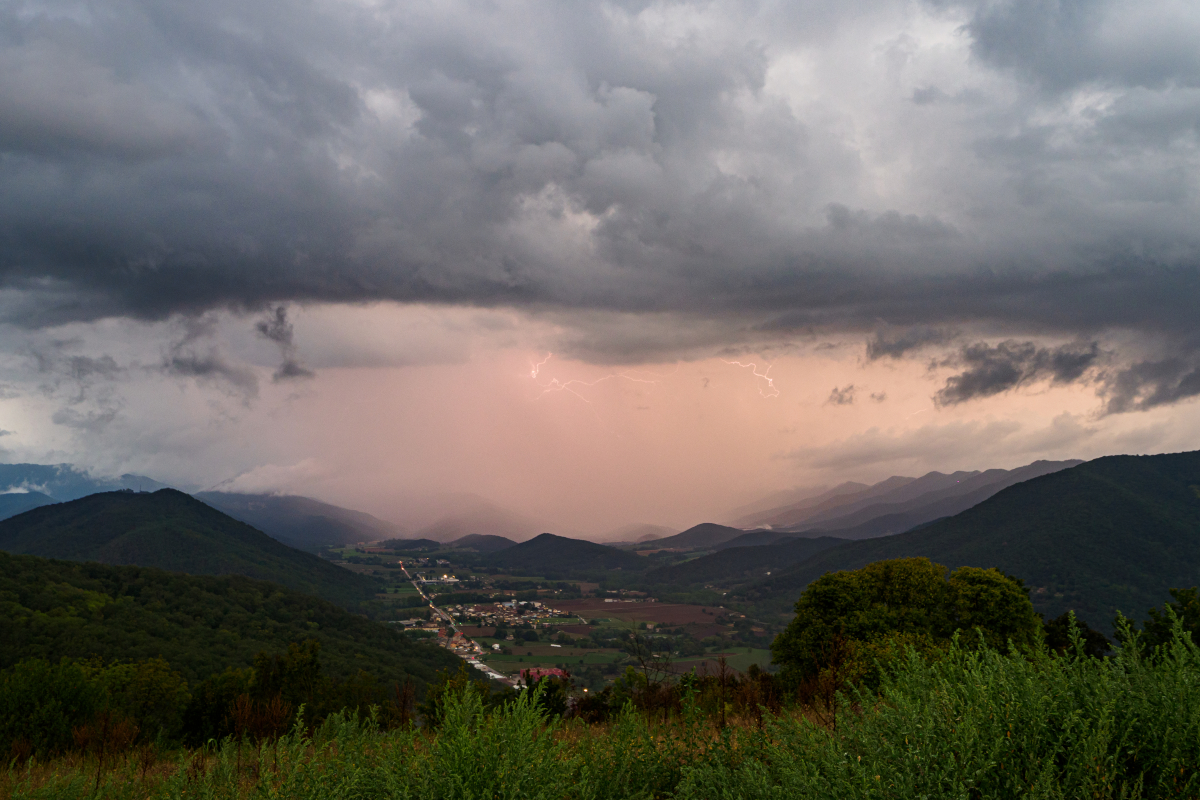 La tormenta pasaba por la Vall de Bianya y la cortina de lluvia se iluminaba de vez en cuando por los rayos.
