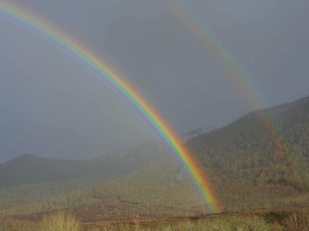 Arco iris doble
Día lluvioso, un rayo de sol y arco iris doble formado en el valle, con las montañas todavía nevadas a principios de mayo
