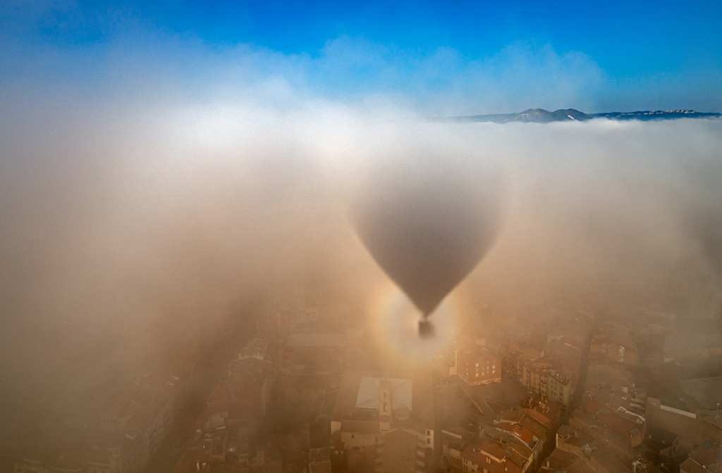 Fantasma sobre la ciudad
28 de marzo de 2021 en Vic, una zona elevada menos habitual, desde el globo con su sombra y esta glorieta entre la niebla que parece un fantasma sobre la ciudad.
