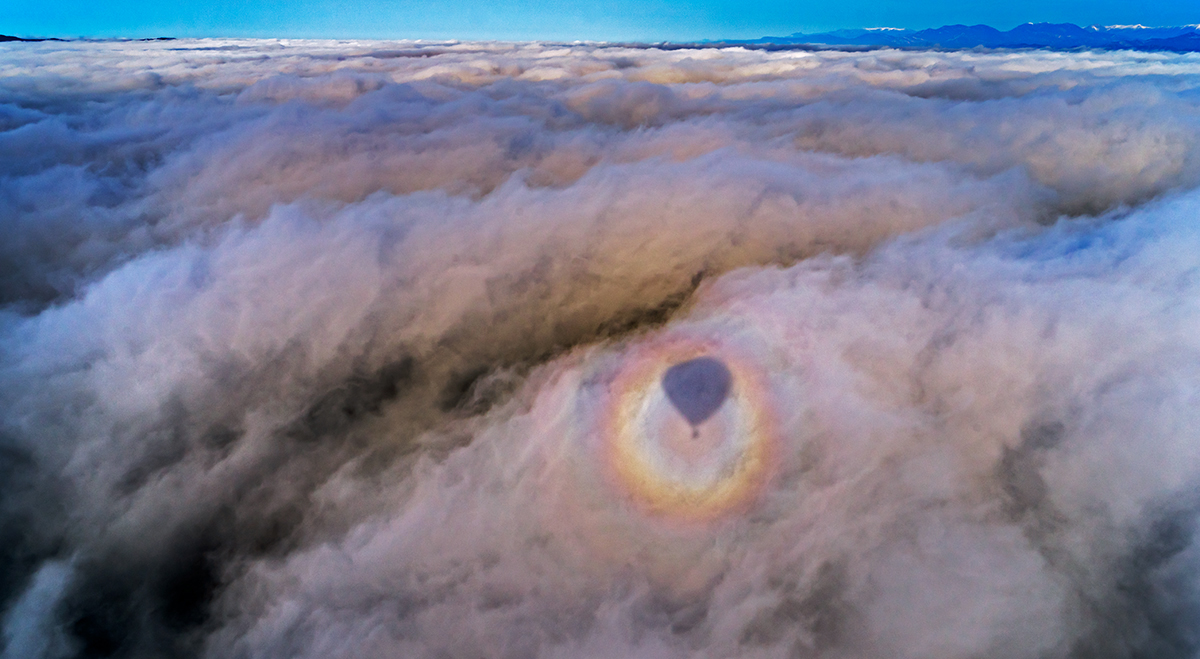 Esta glorieta o Espectro de Brocken sobre la niebla la capturé desde el globo, cuando soplaba un ligero viento como se observa en la niebla. Desde el globo casi siempre se pueden capturar bellas imágenes y alguna vez fenómenos como este. 
En Vic se celebra cada año el “Trofeu Mercat del Ram” de globos, donde se dan cita globos de varios países.

