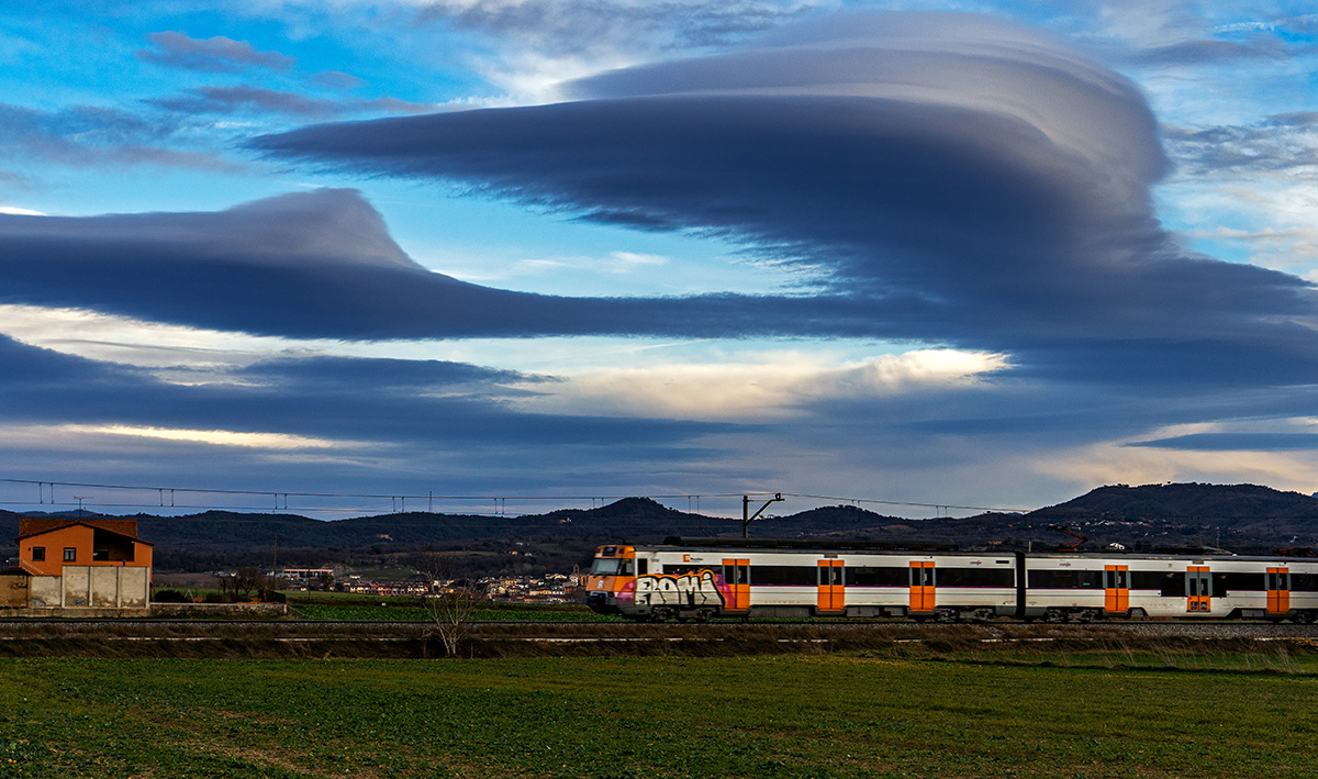 Saliendo de Vic en dirección a Barcelona vemos la última masía, la próxima ya pertenece a Malla, una zona habitual en mis fotos con el tren entre los campos. Pero lo que cuenta meteorológicamente hablando, son estas bellas nubes lenticulares. 
