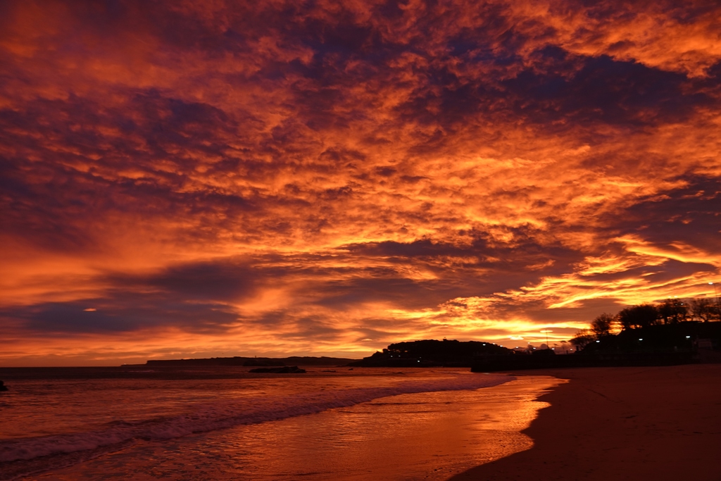 Amanece el 8 de enero de 2025 con una situación de vientos del sur en el Cantábrico, temperatura de 17 grados, viento entre suave y moderado en la playa de El Sardinero, de Santander. Hay una potente y compacta nubosidad de tipo medio, que cobra intensas tonalidades cromáticas, minutos antes de la salida del sol.
Foto que simboliza un invierno de tendencia cálida y con ausencia de olas de frio invernales. 
