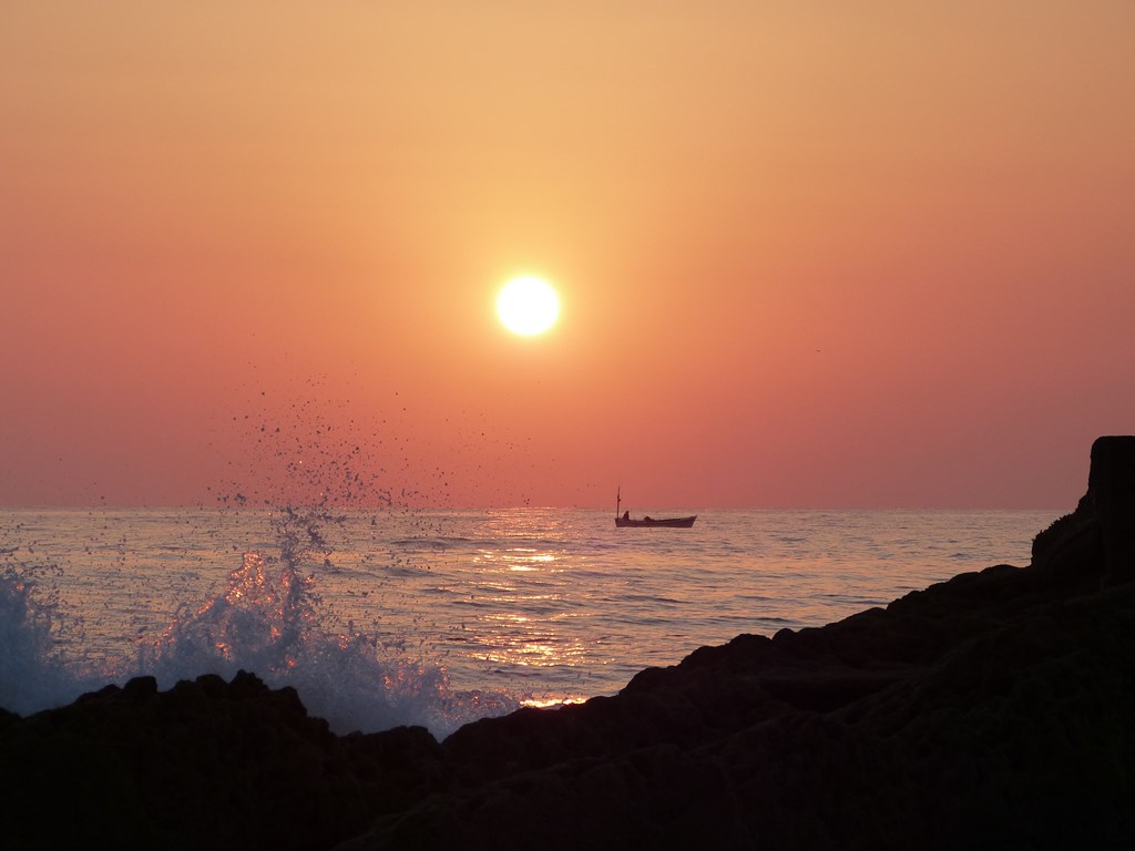 Tranquila espera 
Amanecer tranquilo con pescador al fondo. El reflejo del sol sobre la superficie y sobre la  espuma le aporta unas tonalidades de color dorado y malva. 
