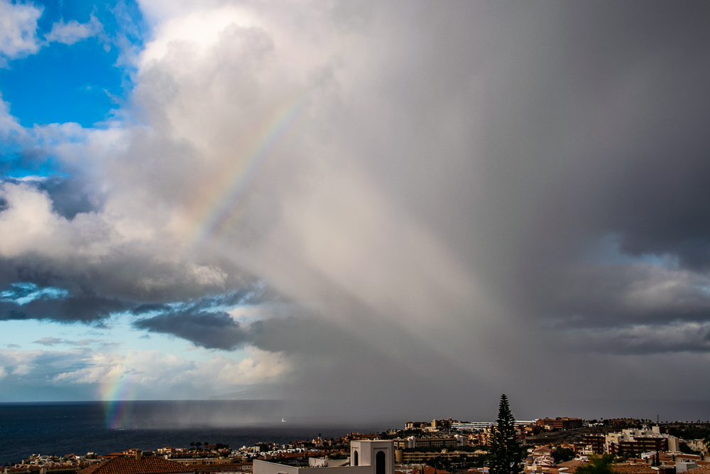arco iris sobre Costa Adeje 
una cortina de precipitacion   al amaneceergenero este arco iris 
