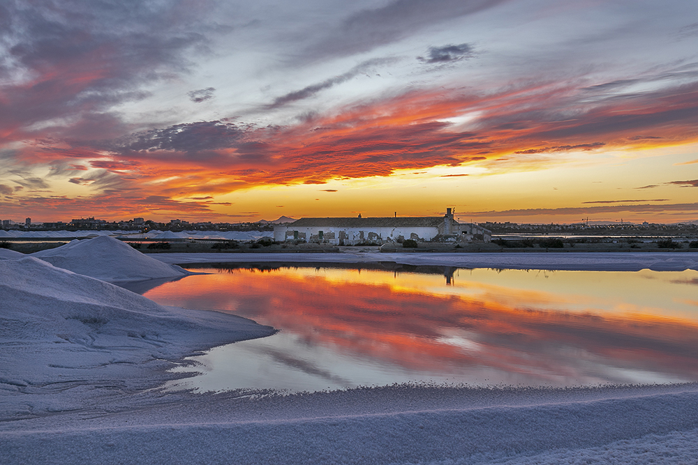 Fui a fotografiar un atardecer en las salinas de San Pedro del Pinatar y las encontré en plena recogida de la sal, formando este bonito contraste entre el blanco níveo de la sal y los tonos rojizos de las nubes.
