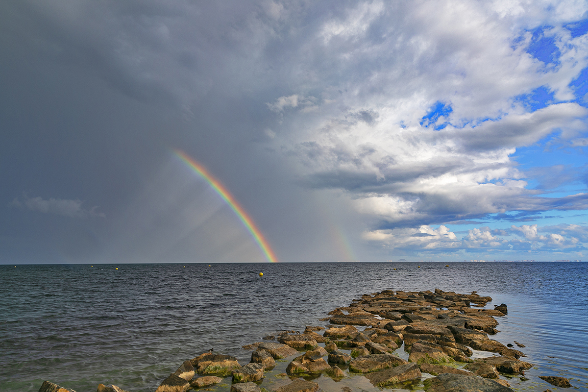 Tras la descarga vespertina de un núcleo tormentoso que llegaba desde el NW y se retiraba al mar, se formó este arco iris con reflejos de tenues rayos de sol.
