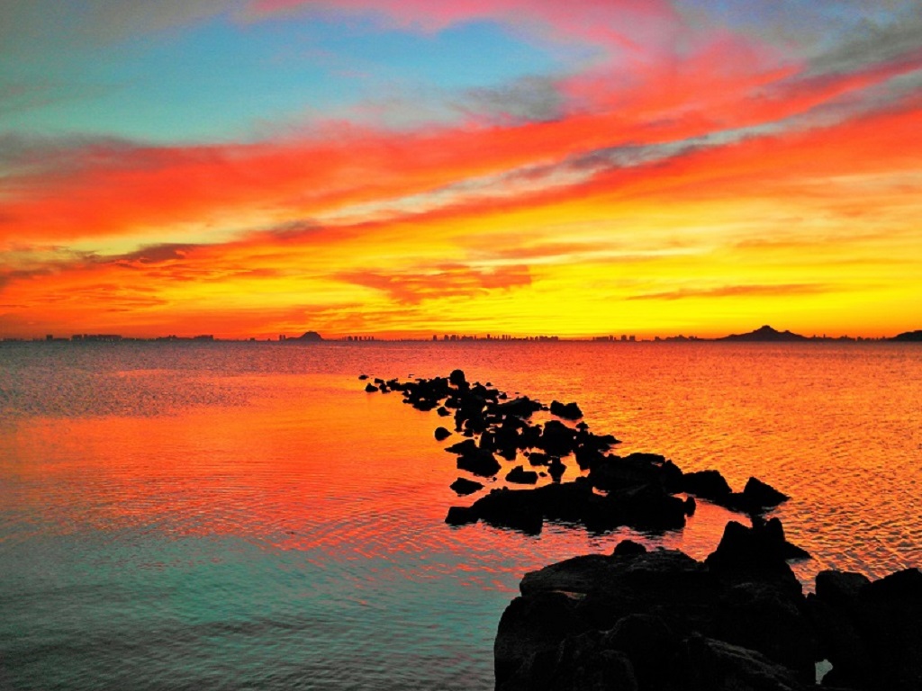 Amanecer en azul y rojo
El tono rojizo del cielo del amanecer anuncia la llegada de un frente frío que clausura el "veroño" del pasado noviembre. El reflejo en el Mar Menor termina por crear esta bella composición.
