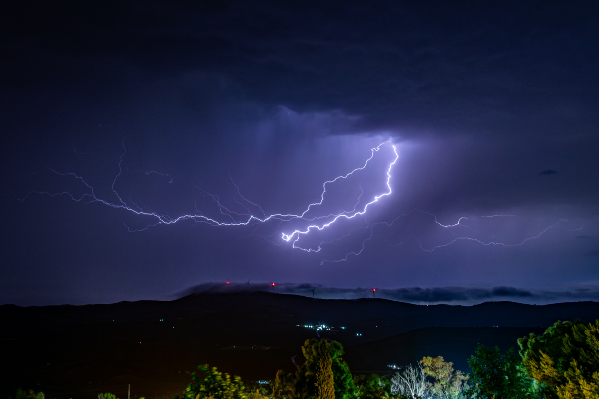 Otra foto más que aquella fantástica noche. Mirando hacia el NW de Archidona, vemos un rayo ramificándose por la base de la tormenta y con algunos estratos que acariciaban la sierra de en frente, haciendo que se ocultaran de vez en cuando los molinos eólicos.
