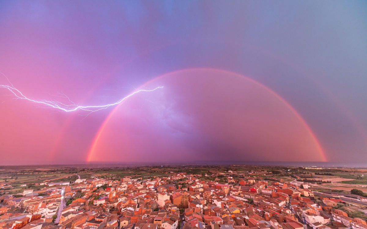 Alguaire, es un pueblo que ronda los 3.000 habitantes, situado en la comarca del Segrià, Lleida. A finales de julio una potentísima tormenta llegó justo en el momento del atardecer. Desde la colina del pueblo contemplamos como los últimos rayos de sol se abrían paso para formar este extraordinario arcoíris doble… mientras los rayos y relámpagos de la tormenta decoraban la escena ofreciendo este espectáculo casi perfecto...de los que no se olvidan fácilmente.
