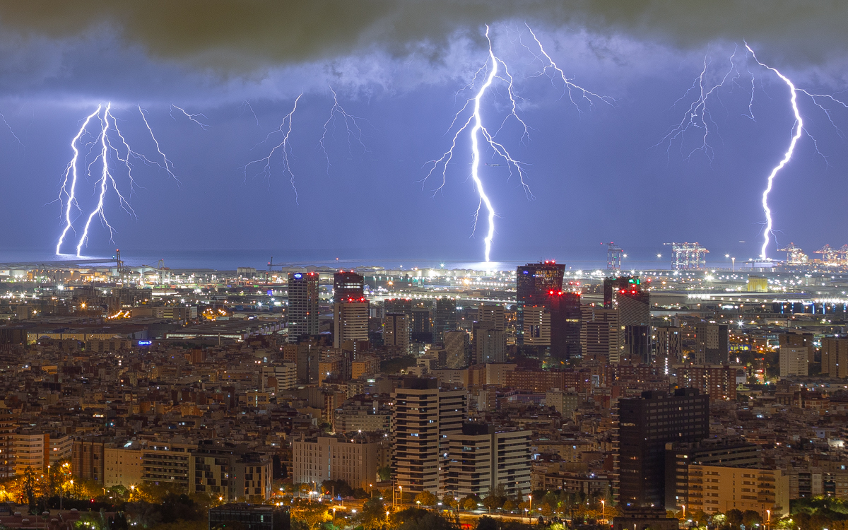 Durante esta noche de finales de octubre, una tormenta llega a Barcelona. Trae consigo mucha actividad eléctrica y deja a su paso gran cantidad de rayos. Durante esta fotografía 3 rayos (uno doble) impactan en el mismo instante cerca del puerto de Barcelona. La potencia de la descarga múltiple ilumina perfectamente un avión que realiza la maniobra de aterrizaje en el aeropuerto de Barcelona.
