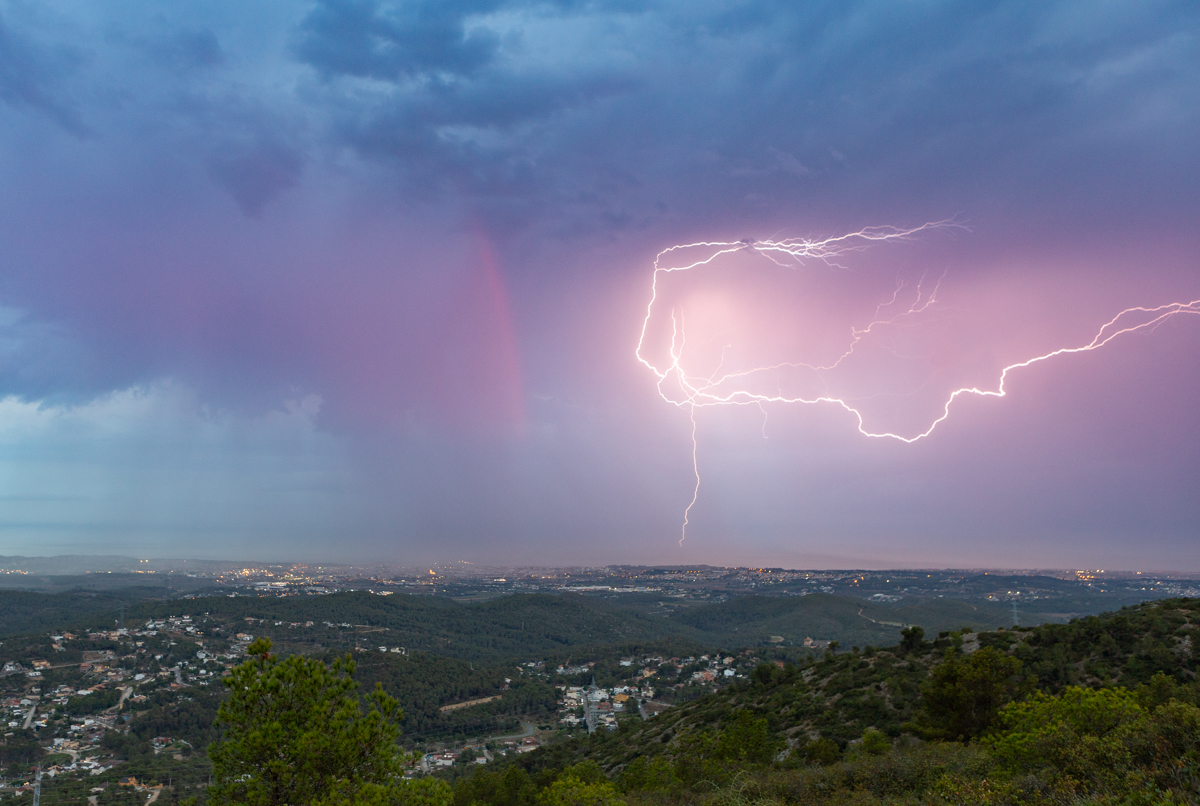 Un rayo cae al mar en esta tormenta de tarde iluminando los trazos finales de un arcoíris que se desvanecía....
