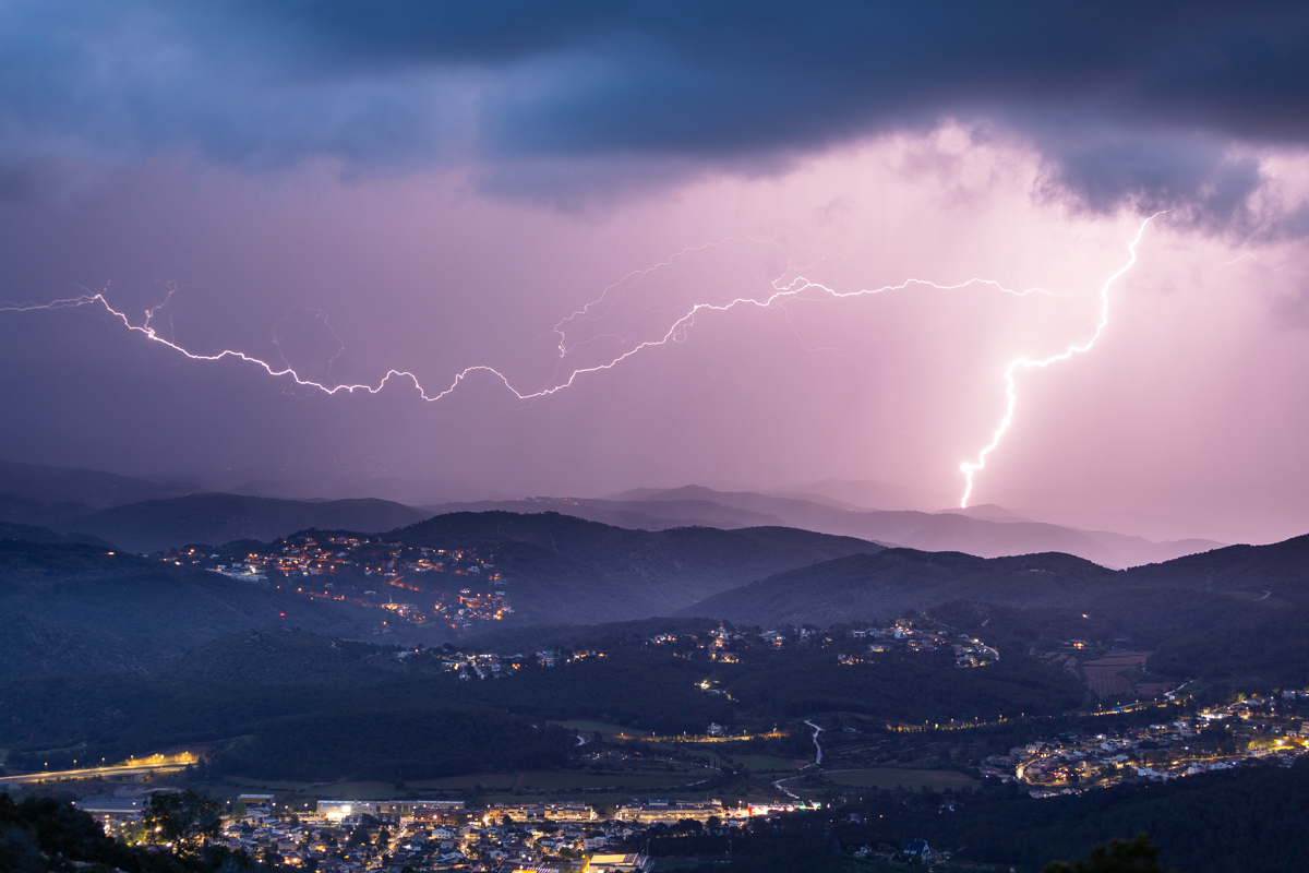 Empieza a anochecer mientras la tormenta se encamina al mar. Un gran rayo ilumina el perfil de la montaña y la densa cortina de lluvia.
