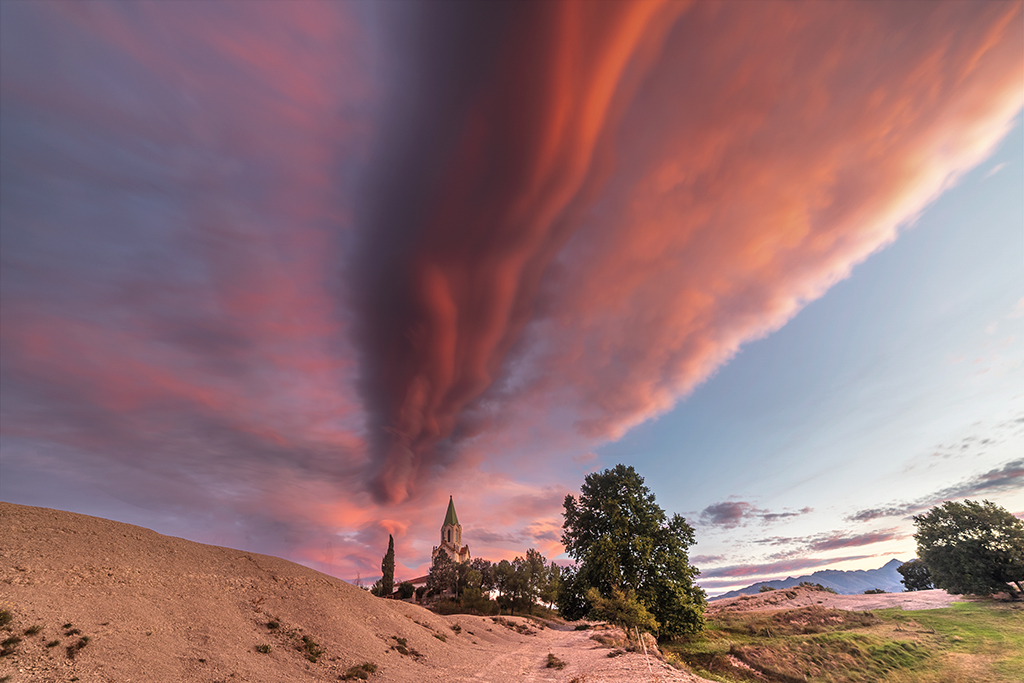 Un espectáculo de nubes lentuculares al amanecer, como un sendero rosado que se extiende desde el santuario hacia el cielo
