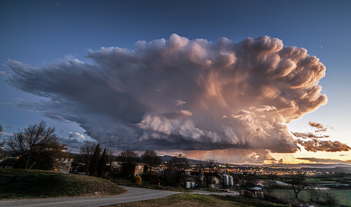 Cumulonimbos imponente de gran impacto visual resaltando la magnificencia de la naturaleza la grandiosidad de la nube de tormenta, se alza con una presencia sobrecogedora, dominante con la luz del ocaso.
A la izquierda, mi casa; al fondo, el pueblo de Manlleu y el Montseny, donde se distingue la cortina de precipitación.

