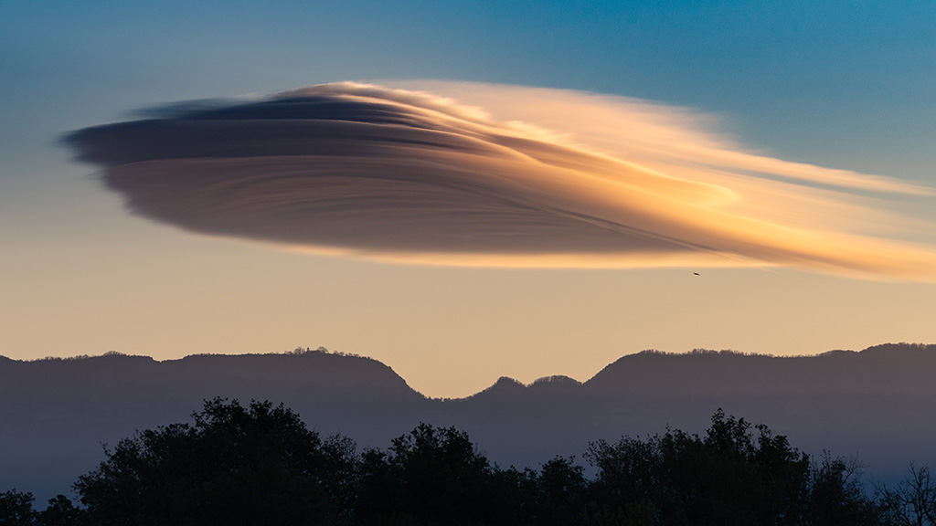 Amanecer ventosos,  con nitidez en la atmosfera  se forman nubes moldeadas en forma de sobrero sobre la montaña, altocúmulos lenticulares
