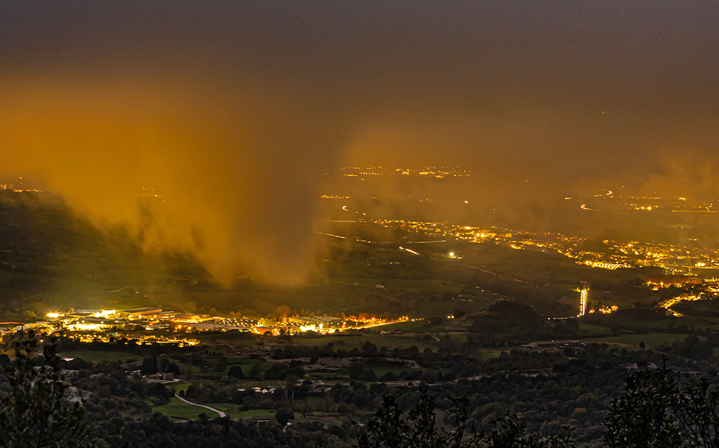 Al filo del alba, surgen espectaculares brumas teñidas por las luces de los pueblos del valle, vistas desde lo alto
