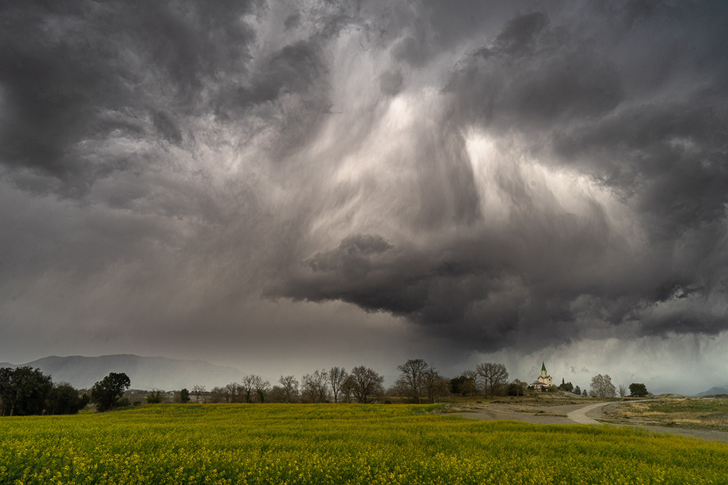 Velo o columna de precipitación sobre el santuario. conecta las nubes con el horizonte de color gris tenue. Embellece aún más los paisajes de los campos con los colores primaverales.
