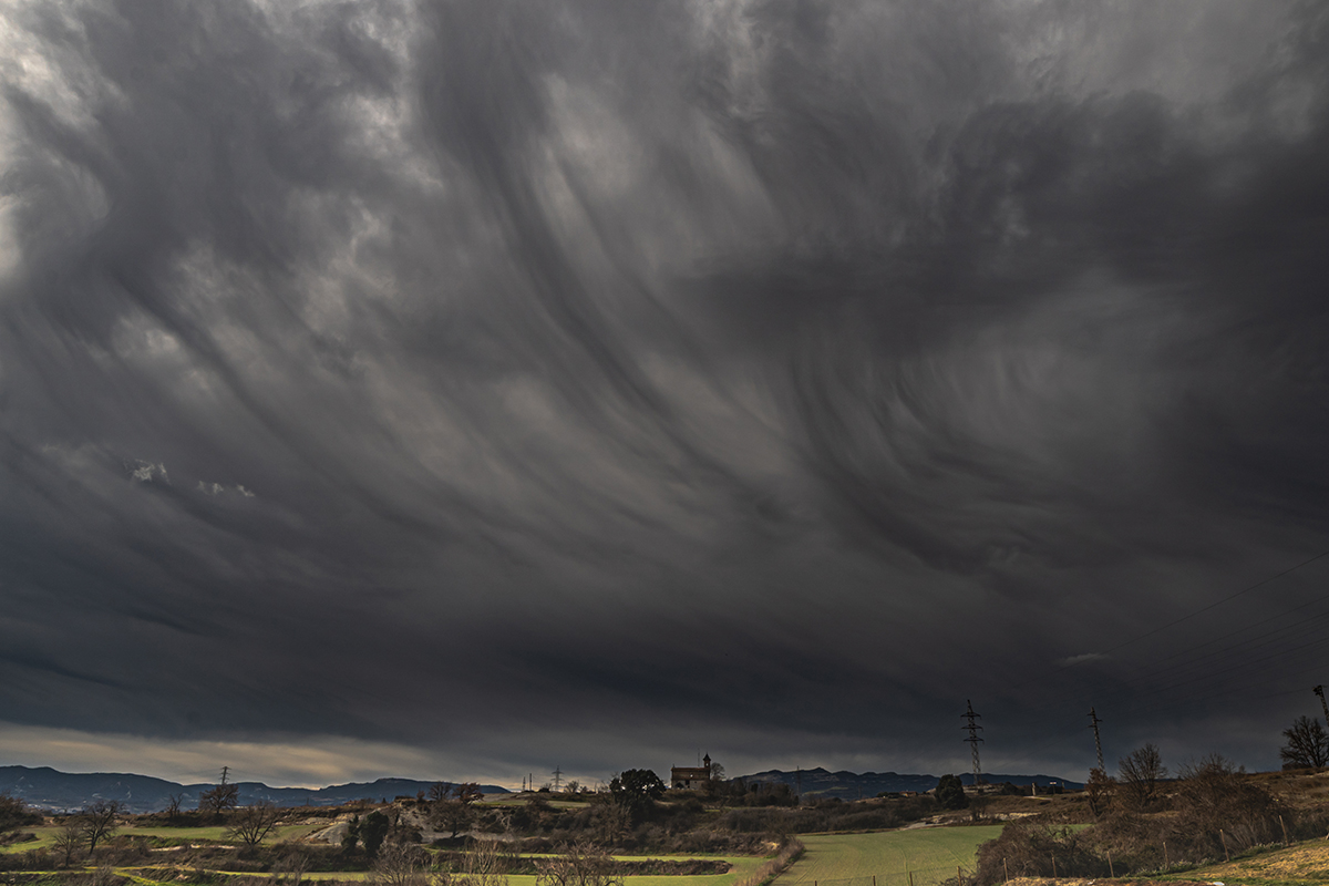 Virgas, tonos oscuros del cielo y la estructura ondulante de las nubes generan una sensación de dinamismo, como si el cielo estuviera en flujo constante.

