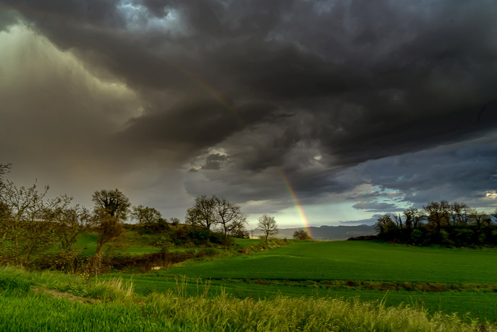 Cortina de lluvia y el arcoíris
Espesa cortina de lluvia da lugar a un brillante arco iris sobre un paisaje primaveral.
