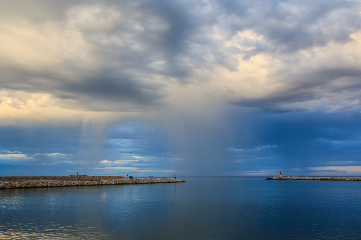 Cortinas de lluvia precipitando en la bocana del puerto a última hora de la tarde.
