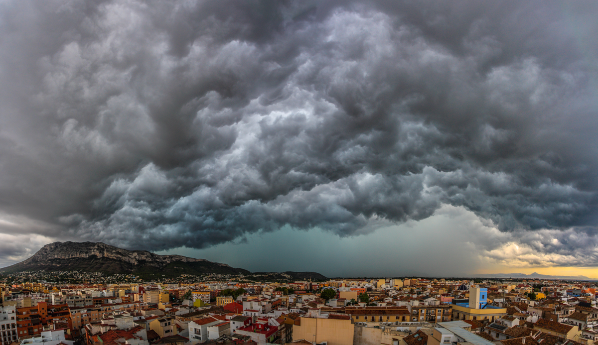 Este coloso asociado a un tren de tormentas organizado a raíz de una DANA, llegó a Dénia desde el noroeste a primera hora de la tarde el 14 de agosto, con gran estruendo de truenos, viento fuerte y posterior lluvia. Al principio daba la sensación de que se desplazaba hacia el sur pero, o bien viró al este o bien se ensanchó y en pocos minutos el arcus frontal se situó sobre mi posición dejando un cielo apocalíptico y difícil de capturar por su extensión (la imagen es una panorámica compuesta de 5 fotos verticales). Después de 1 hora precipitando (en Dénia se recogieron ese día entre 30 y 57 l/m2) avanzó mar adentro hacia la Pitiusas causando un temporal inédito y destrozos considerables en Formentera.
