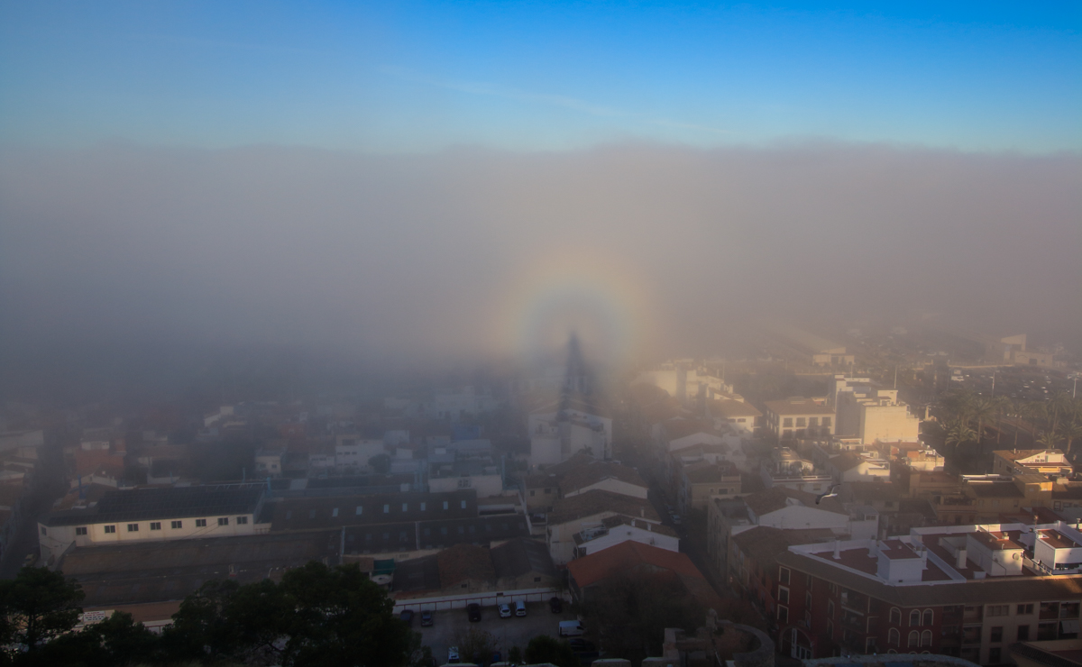 Desde lo alto del castillo pude contemplar mi sombra formando un espectro, gloria incluída, proyectada sobre las nieblas de advección que en ese momento entraban a la ciudad. Detrás, aunque no se vea, está el mar. Esta era una imagen que había planeado conseguir hacía tiempo, pero para ello necesitaba que las nieblas se dieran por la tarde, con el sol cayendo por el oeste, ese día todo encajó para lograrlo.
