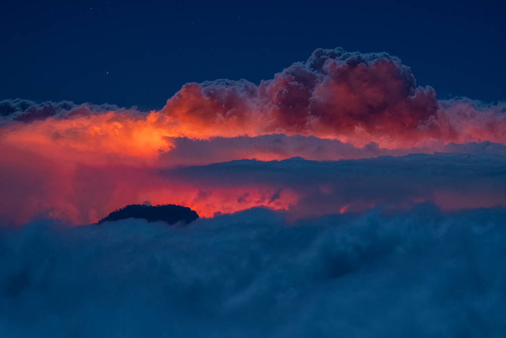Mar de nubes volcánico
A 2000 metros de altura se puede apreciar el penacho de humo del volcán de La Palma sobresaliendo por encima del mar de nubes. El color rojo se debe a la iluminación del magma incandescente centenares de metros más abajo.
Álbumes del atlas: zfo21 z_top10trim_mrsycscds