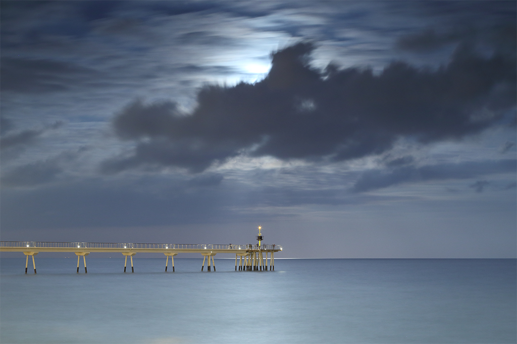 Luna oculta
Nubes en movimiento ocultan la luna llena sobre el Puente del Petróleo de Badalona. 
