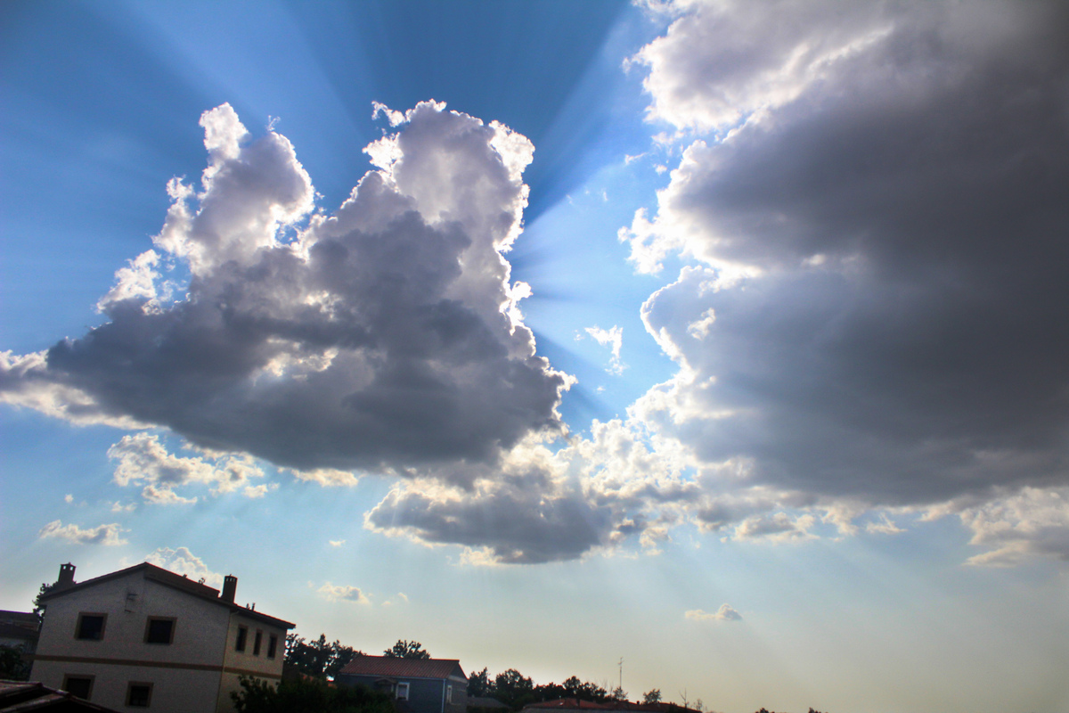 Proyección de rayos de sol tras esconderse este detrás de esta simpática nube veraniega 
