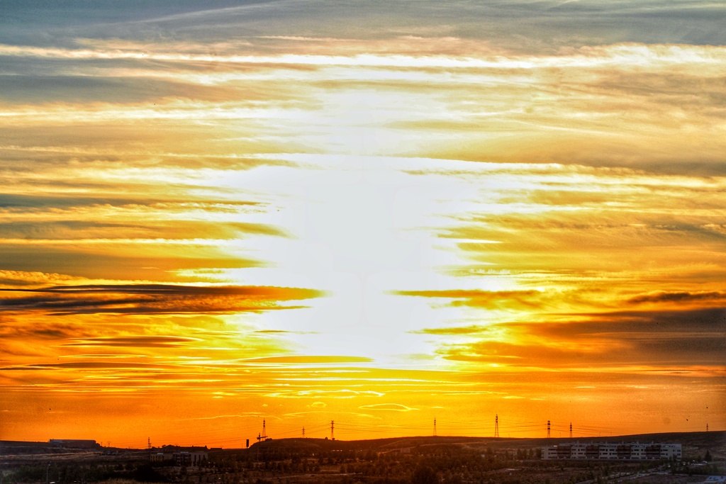 Si mi conocimiento no me falla creo que se trata de nubes Cirrostratus cubriendo el sol en el momento del ocaso , fotografía del 13 de junio al inicio del verano 
