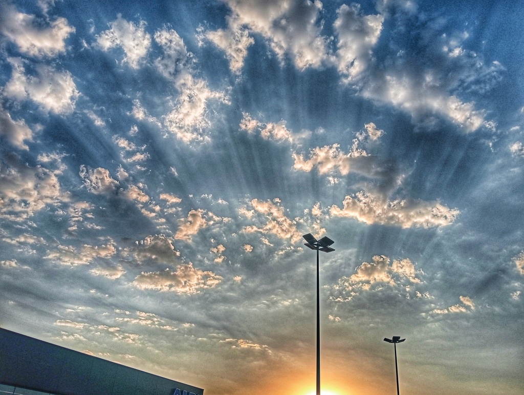 Precioso atardecer captado también la tarde bochornosa del 24 de julio con el sol escondido detrás de los edificios formando estos rayos entre las nubes
