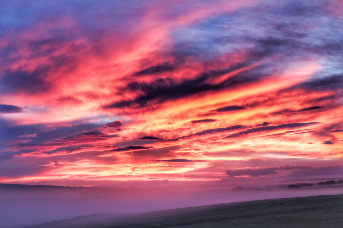 Candilazo de ayer por la mañana junto a los bancos de niebla coloreados por el amanecer y algún rayo del alba 
