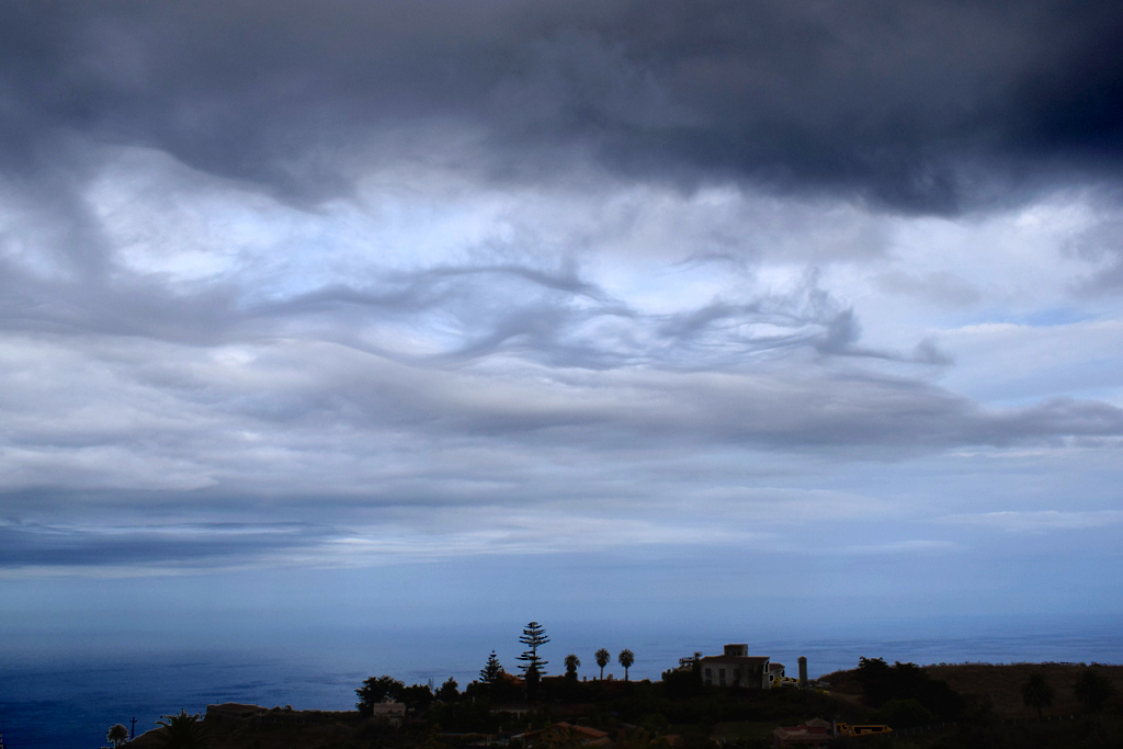 Nubes fantasma
Formadas a sotavento de las cumbres de la isla, en un cielo caótico.
