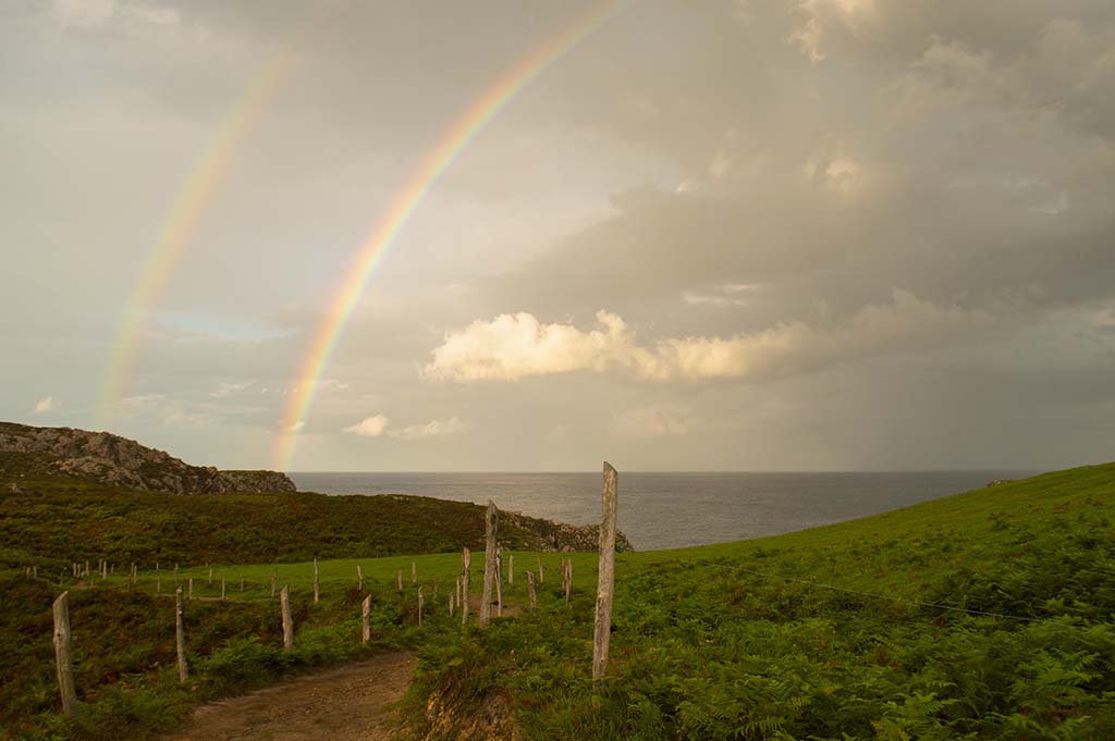 Cielo y tierra.
Camino entre prados, mar cantábrico y doble arcoíris.
