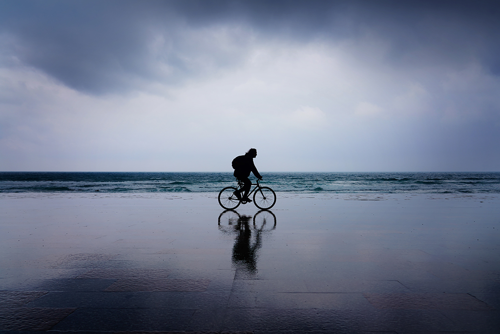Malecón de Zarautz
Mediodía lluvioso en Zarautz. Un ciclista, ajeno al mal tiempo, pasea por el malecón, junto al mar.
